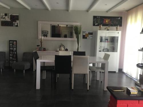 une salle à manger avec une table et des chaises blanches dans l'établissement Villa paisible, à Canohès