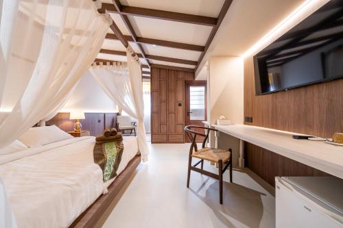 a bedroom with a bed and a desk in a room at Athithara Homestay in Phra Nakhon Si Ayutthaya
