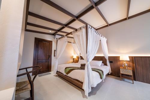 a bedroom with a bed with a canopy at Athithara Homestay in Phra Nakhon Si Ayutthaya