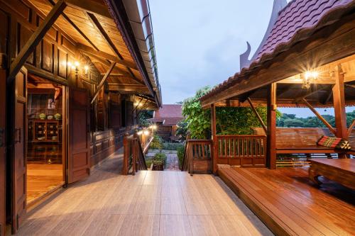 a wooden deck with benches and tables on a building at Athithara Homestay in Phra Nakhon Si Ayutthaya