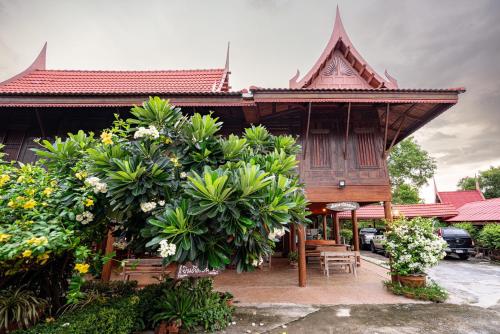 a wooden house with plants in front of it at Athithara Homestay in Phra Nakhon Si Ayutthaya