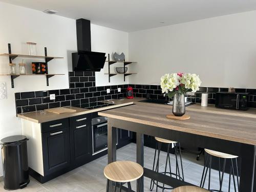 une cuisine avec une table avec un vase de fleurs dans l'établissement LONOMA - Maison entière terrasse couverte et jardin clos, à Digoin
