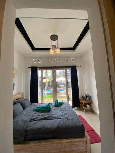a bedroom with a large bed and a large window at Batur Homestay and Lodge in Bangli
