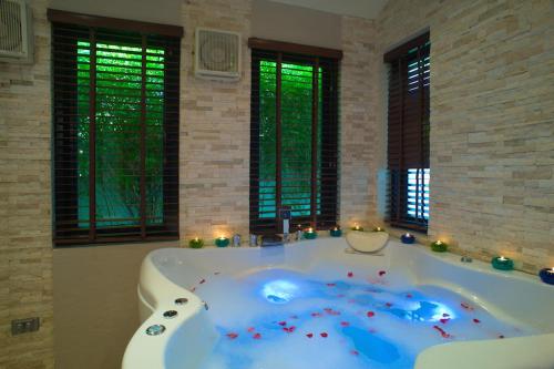 a large bath tub in a room with windows at Koh Samui Lifestyle Private Luxury Beach Front Villas in Plai Laem