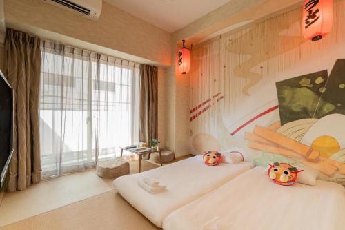 two stuffed animals sitting on two beds in a room at V's Boutique House in Osaka
