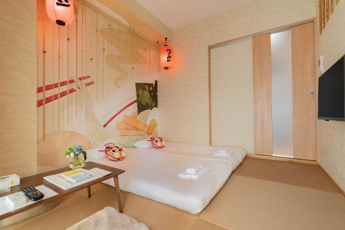 大阪市にあるV の Boutique Houseのベッドとピエロの枕が置かれたテーブルのある部屋