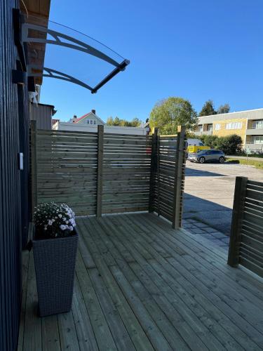 a wooden deck with a fence and a plant at Rest and Stay in Piteå
