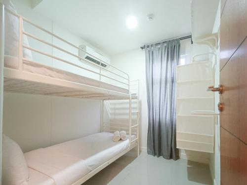a small bedroom with two bunk beds in it at Comfortable and Tidy 2BR at Vida View Apartment By Travelio in Pampang