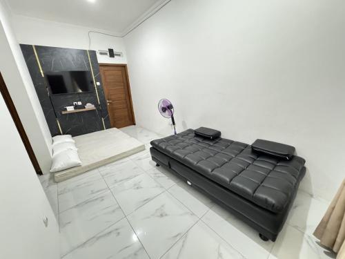 a black couch in a room with a bathroom at Omah Sidokarto Homestay Jogja in Godean