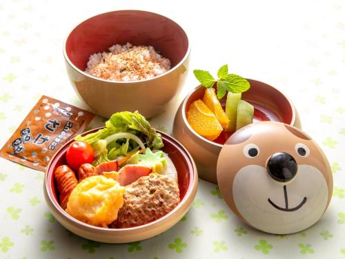 a bowl of food with a teddy bear face next to some food at 河内長野荘 in Nagano