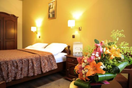 a hotel room with a bed and a bouquet of flowers at Hotel Kreta in Galaţi