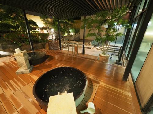 a room with a large tub on a wooden floor at Nara Plaza Hotel in Tenri
