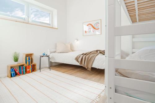 a white bedroom with a bunk bed and a window at Reihe 7 in Kappeln