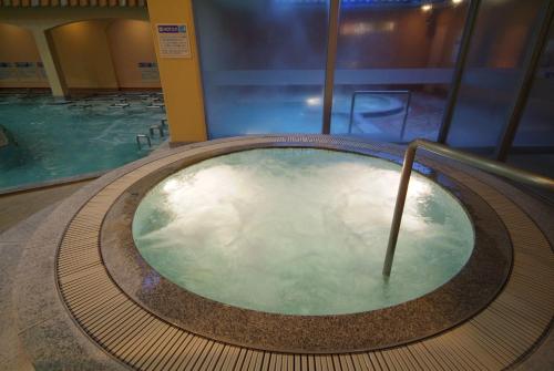 a hot tub in a building with a swimming pool at Nara Plaza Hotel in Tenri