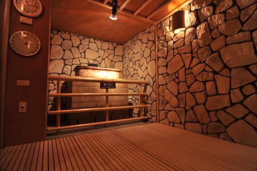 a room with a bed and a stone wall at Nara Plaza Hotel in Tenri