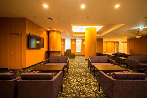 a waiting room with tables and chairs in a building at Nara Plaza Hotel in Tenri