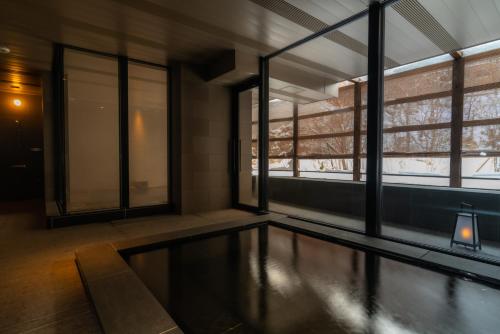 a swimming pool in a room with windows at Chalet Ivy Jozankei in Jozankei