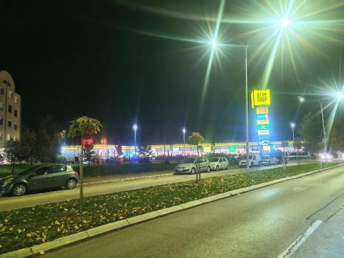 a street at night with cars parked in a parking lot at Linden Avenue Apartment - self check in in Čačak