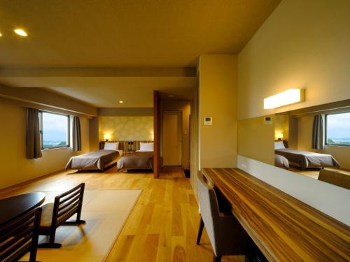 a large room with two beds and a dining room at Inasayama Kanko Hotel in Nagasaki