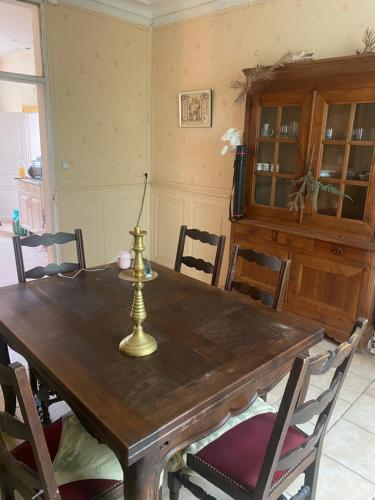 une salle à manger avec une table et des chaises en bois dans l'établissement Maison de Fatiha, à Saint-Sornin-Leulac
