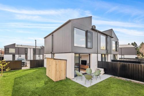 a modern house with a yard with a fence at Mt Roy Delight in Wanaka