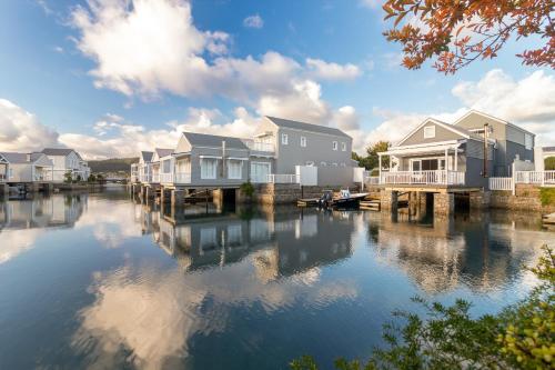 a row of houses on a dock next to a body of water at Turbine Villa in Knysna