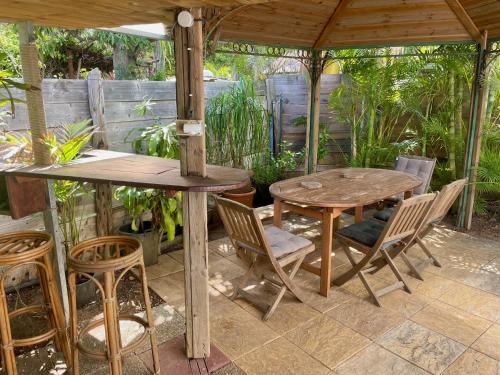 拉萨尔勒班Saline les bains petite maison bien aménagée calme & plage à pied的凉亭下的木桌和椅子