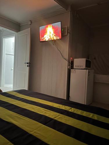 a room with a bed with a tv on the wall at Ахметова 4 in Krasnoye Pole
