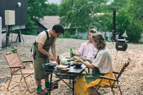 a group of people sitting around a picnic table at Earthboat Togakushi in Nagano