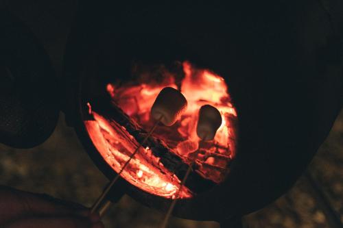 a person is cooking food over a fire at Earthboat Togakushi in Nagano