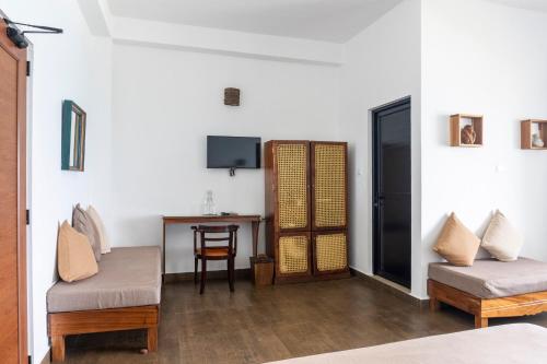 a room with two chairs and a table with a television at Bay Vista in Arugam Bay