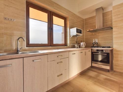 a kitchen with white cabinets and a window and a sink at U Pawlikowskich in Poronin