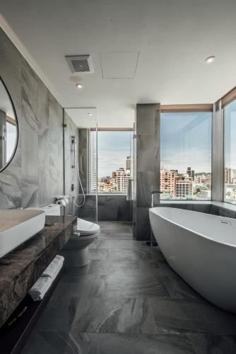 a bathroom with two sinks and a tub and two toilets at Harbour 10 Hotel in Kaohsiung