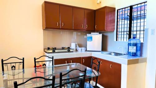 a kitchen with wooden cabinets and a table with chairs at Ormoc Libertad Gate 2 in Ormoc