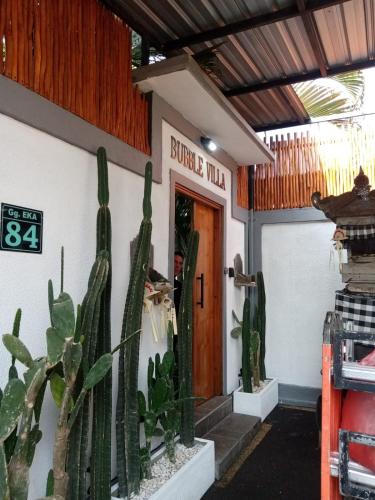 a building with cactuses in front of a door at Bubble Villa & Rice field view in Kerobokan