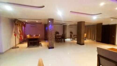 a dining room with a table and chairs and purple lighting at HOTEL CROWN PALACE Bihar in Patna