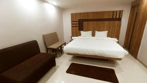 a bedroom with a bed and a chair and a couch at HOTEL CROWN PALACE Bihar in Patna