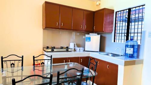 a kitchen with wooden cabinets and a table with chairs at Ormoc Libertad Gate 3 in Ormoc