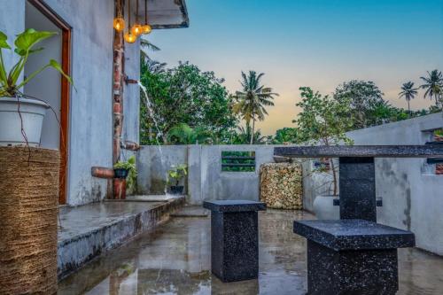 a patio with two tables and a toilet in the rain at Aqua Lina Villa in Matara