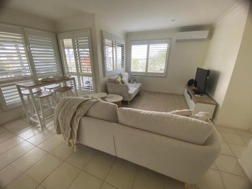 a living room with a couch and a table at Bungalow by the River in Shoalhaven Heads