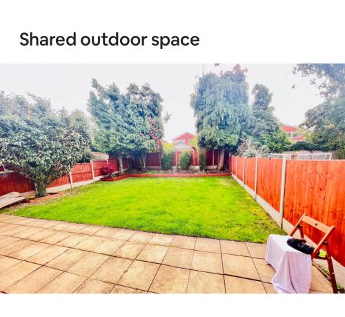 a backyard with a fence and a grass yard at Luxury room near train station and city centre in Stivichall