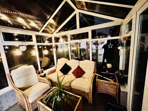 a living room with chairs and a table and a glass table sidx sidx at Luxury room near train station and city centre in Stivichall