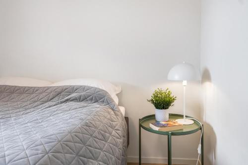 a bedroom with a bed and a table with a lamp at Book an apartment just for you in central Tromsø in Tromsø