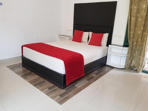 a bedroom with a bed with a red blanket on it at Kairali Palace Home Stay in Thekkady