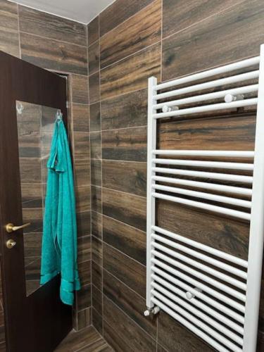 un bagno con un asciugamano appeso a una parete di legno di Chic Urban Retreat a Drîmbar