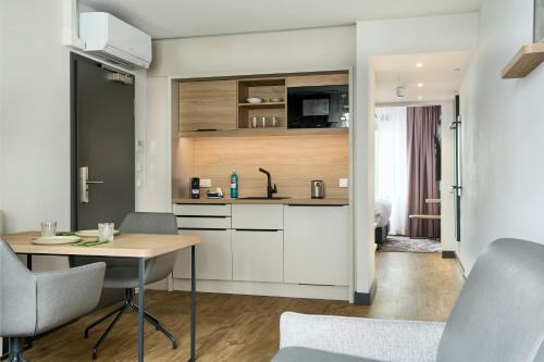a kitchen and dining room with a table and chairs at June Six Hotel Hannover City in Hannover