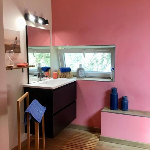 une cuisine rose avec évier et fenêtre dans l'établissement La chollerie de Marmaju, à Basseneville