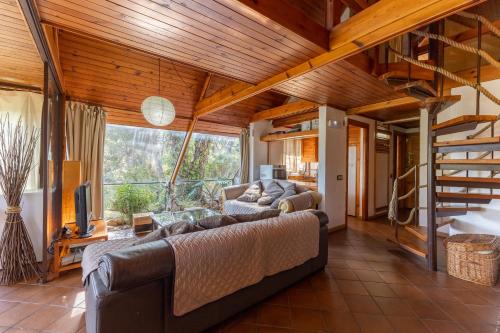 Una sala de estar con un sofá y una escalera. en Casa De Cuento, en San Martín de Valdeiglesias