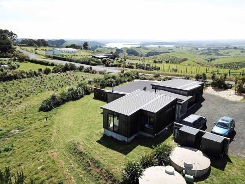 an overhead view of a house on a hill with a car at The Coastal Retreat in Raglan