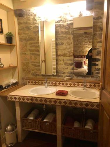 une salle de bain avec deux lavabos et un grand miroir dans l'établissement Le clos de fougères Les Fleuriéres, à Montoillot